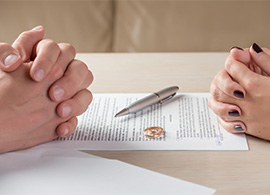 Pareja con un Documento de Divorcio Ante una Oficina de Abogados