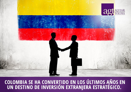 Hombres de negocios estrechándose las manos con bandera colombiana 